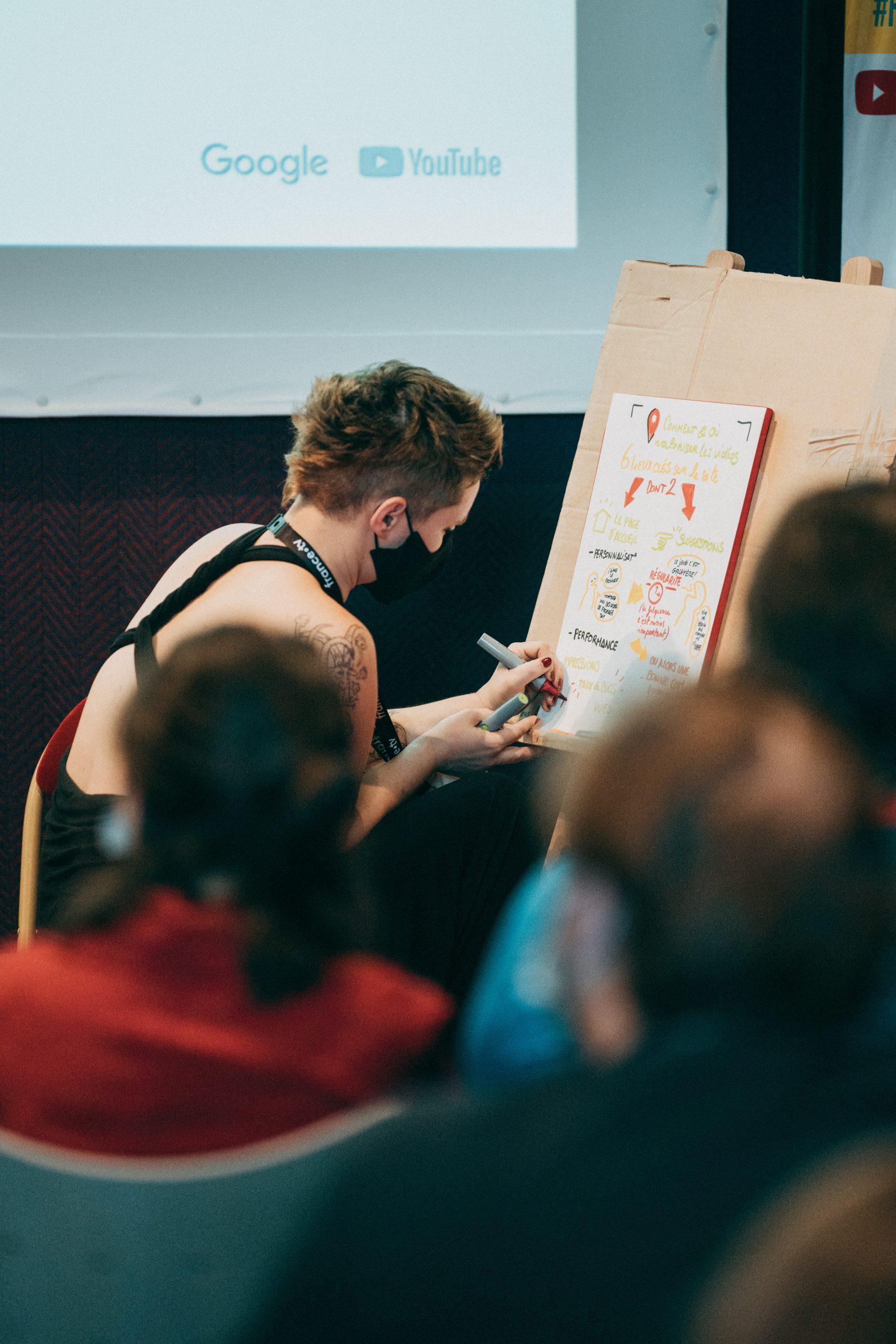 éditions précédentes Frames Pro : photo d'une femme aux cheveux courts en train d'écrire sur une feuille